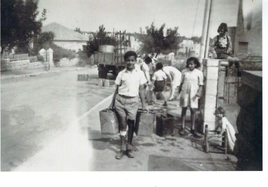 "הגעתי לירושלים עם בגדים מלוכלכים בדם, אבל שלם בגופי". נאור מחלק מים בירושלים במלחמת השחרור. | מתוך האוסף המשפחתי