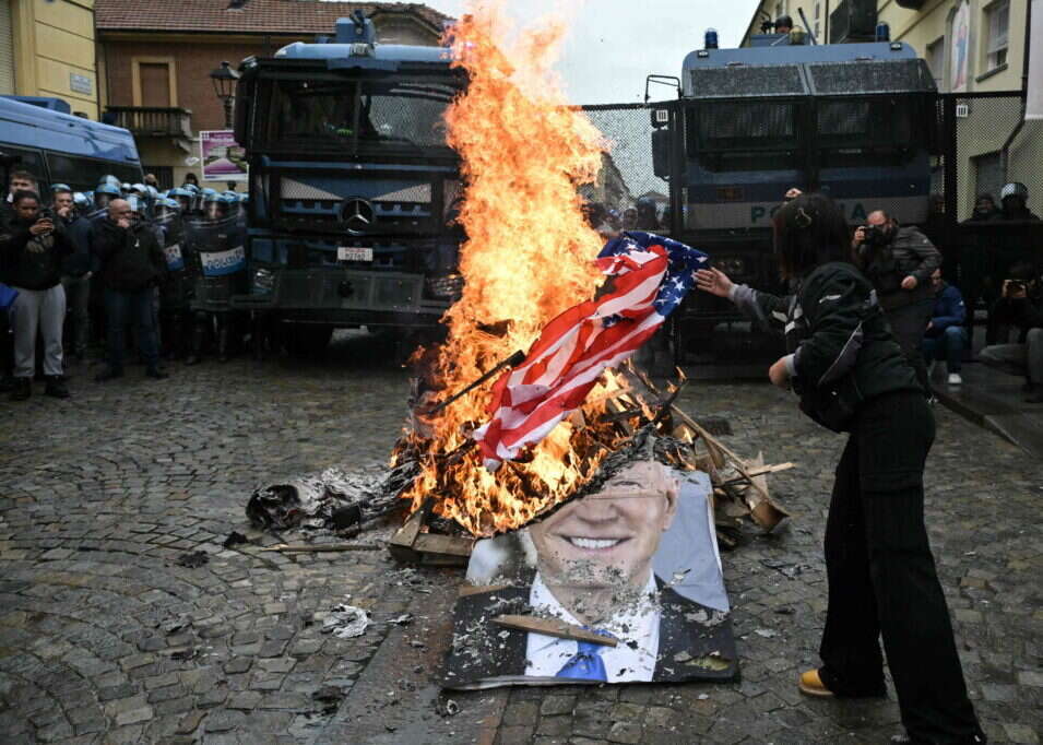 שריפת של דגל ארה"ב ותמונתו של ביידן על-ידי מפגינים באיטליה. AFP שריפת של דגל ארה"ב ותמונתו של ביידן על-ידי מפגינים באיטליה. AFP