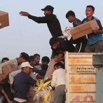 עזתים מרוקנים ציוד ממשאיות הסיוע שנכנסו לרצועת עזה מהמזח האמריקני. | AFP