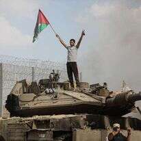 מחבלים עומדים על טנק צה"ל בוער ב-7 באוקטובר | יוסף מוחמד/פלאש90