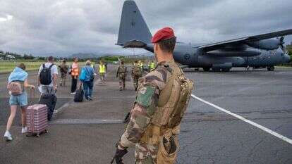 המרד בקלדוניה החדשה. חייל ניו־זילנדי מאבטח השבוע תיירים שנמלטים מהארכיפלג במטוס צבאי מיוחד. | איי.אף.פי