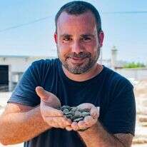 הארכיאולוג שחר קריספין מחזיק את מטמון המטבעות לאחר מציאתו. | יולי שוורץ