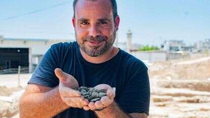 הארכיאולוג שחר קריספין מחזיק את מטמון המטבעות לאחר מציאתו. | יולי שוורץ הארכיאולוג שחר קריספין מחזיק את מטמון המטבעות לאחר מציאתו. | יולי שוורץ