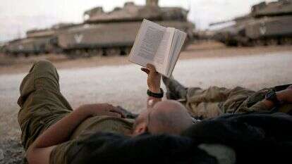 חייל ישראלי קורא ספר בגבול רצועת עזה. | אמיר כהן - רויטרס