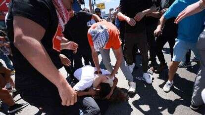 תומכי חמאס עטויי כאפיות מכים יהודי מחוץ לבית כנסת בלוס אנג'לס. | AFP