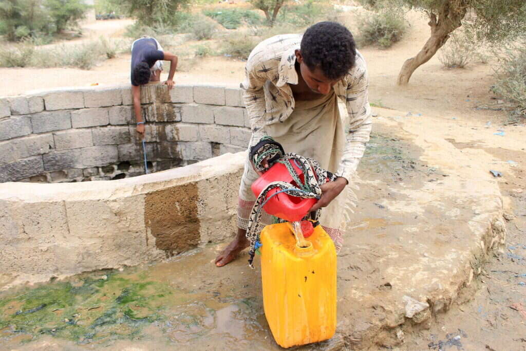 גבר ממלא מים מבאר עקב המחסור הקשה במים בתימן. | AFP