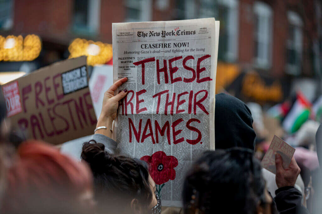 "האובססיה עם הניו־יורק טיימס היא כמו להישאר במערכת יחסים עם גבר מתעלל". הנפת עיתון מזויף בהפגנת תמיכה בחמאס, בברוקלין. | גטי אימג'ס
