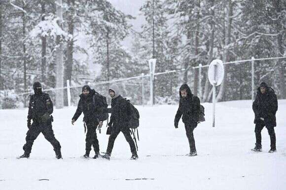אנשי משמר הגבול של פינלנד עם מהגרים בגבול עם רוסיה. | Emmi Korhonen / Lehtikuva / AFP אנשי משמר הגבול של פינלנד עם מהגרים בגבול עם רוסיה. | Emmi Korhonen / Lehtikuva / AFP