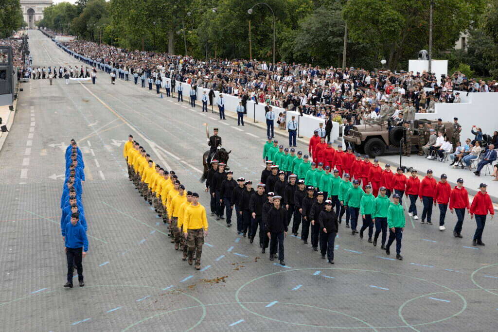 "הביקור בפריז נעשה הרבה פחות נעים". הלפיד האולימפי עובר במרכז העיר במצעד יום הבסטיליה. | אי.פי.איי