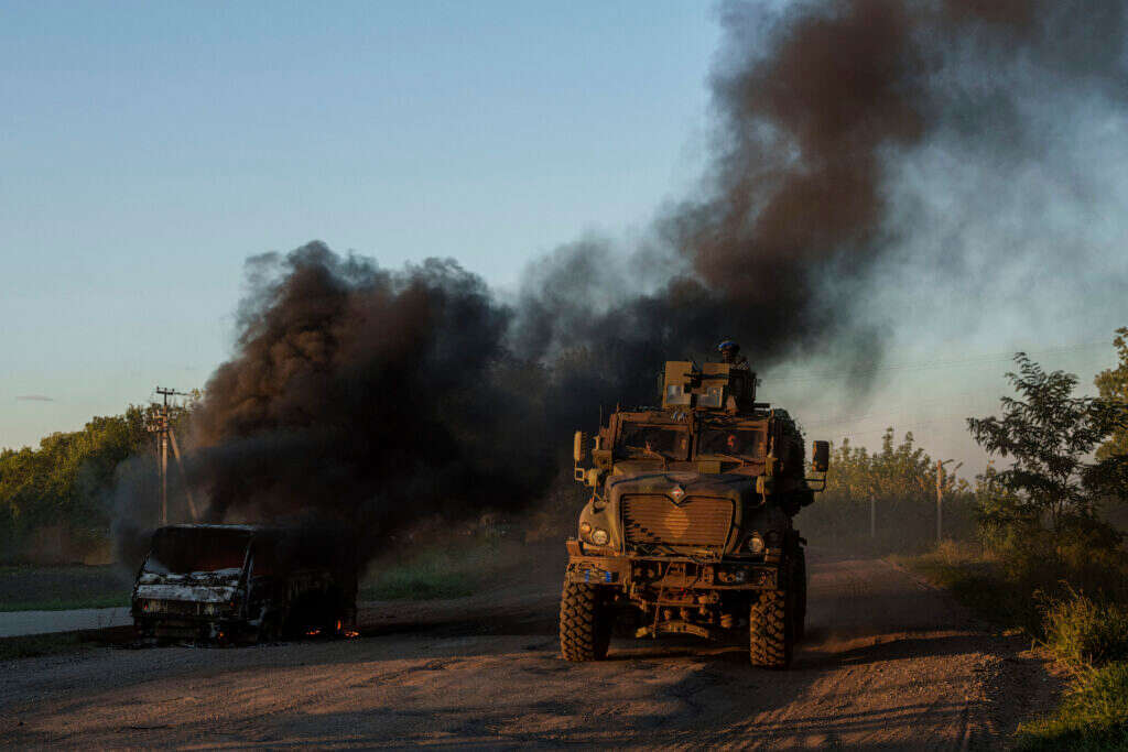 משוריין של צבא אוקראינה חולף ליד מכונית בוערת סמוך לגבול, שבוע שעבר. | איי.פי משוריין של צבא אוקראינה חולף ליד מכונית בוערת סמוך לגבול, שבוע שעבר. | איי.פי
