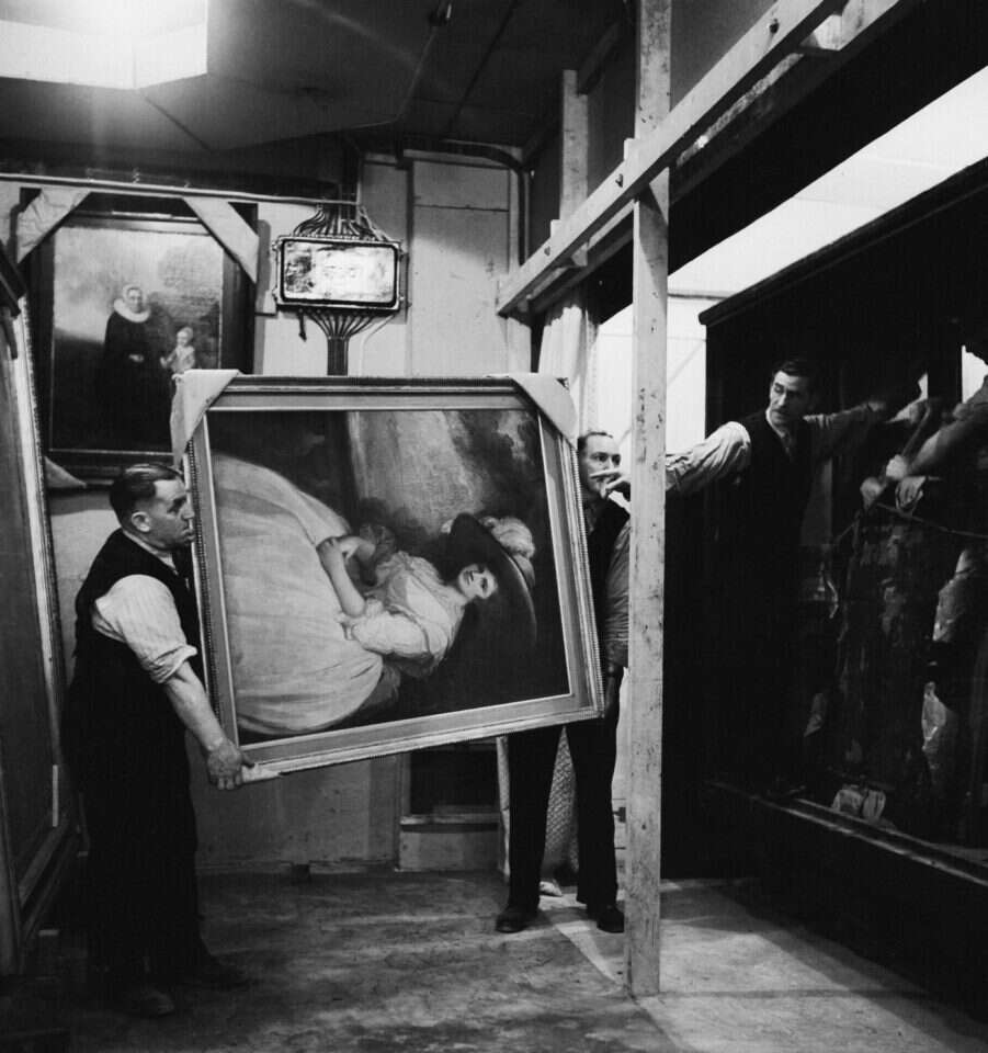 דאגת עובדי המוזיאון, 1942 אנשי הנשיונל גאלרי הבריטית מפנים את ציור המופת "דיוקנה של גברת", מאת ג'ורג' רומני מהמאה ה־ 18 למשמר במכרות מאנוד בוויילס, אחרי שהוצג בתור "ציור החודש" למבקרי המוזיאון בעת המלחמה. | גטי אימג'ס