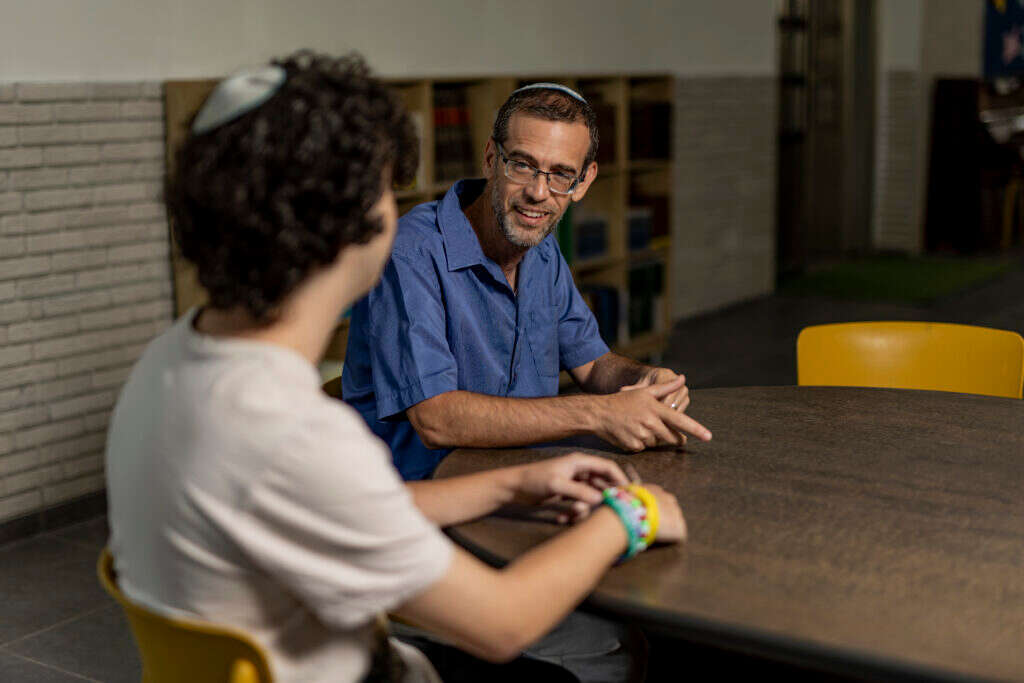 "אני מתגעגע ועצוב, מרשה לעצמי לבכות ולשתף את התלמידים. אבל כאמור, בית הספר הוא מקום שמח וחי". לופז ואחד התלמידים. | נעמה שטרן