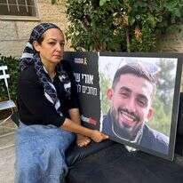 עינב דנינו עם תמונה של בנה אורי ז"ל בחצר ביתה שבשכונת רמות. | עמיאל ירחי