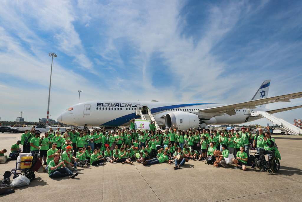 חבורה שמחה עם כוח בחולצות ירוקות זוהרות. מחנה הקיץ בנמל התעופה באמסטרדם. | זכרון מנחם