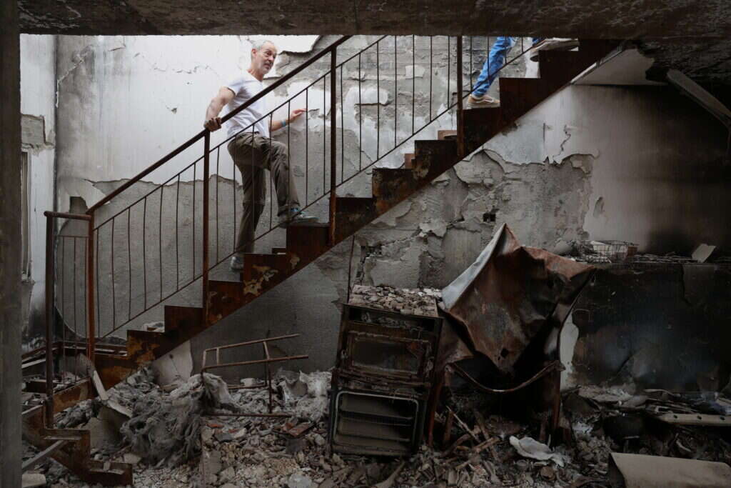 בני משפחת אלון בביתם ההרוס בקיבוץ בארי במהלך טקס האזכרה לטבח ה-7 באקטובר. | EPA בני משפחת אלון בביתם ההרוס בקיבוץ בארי במהלך טקס האזכרה לטבח ה-7 באקטובר. | EPA