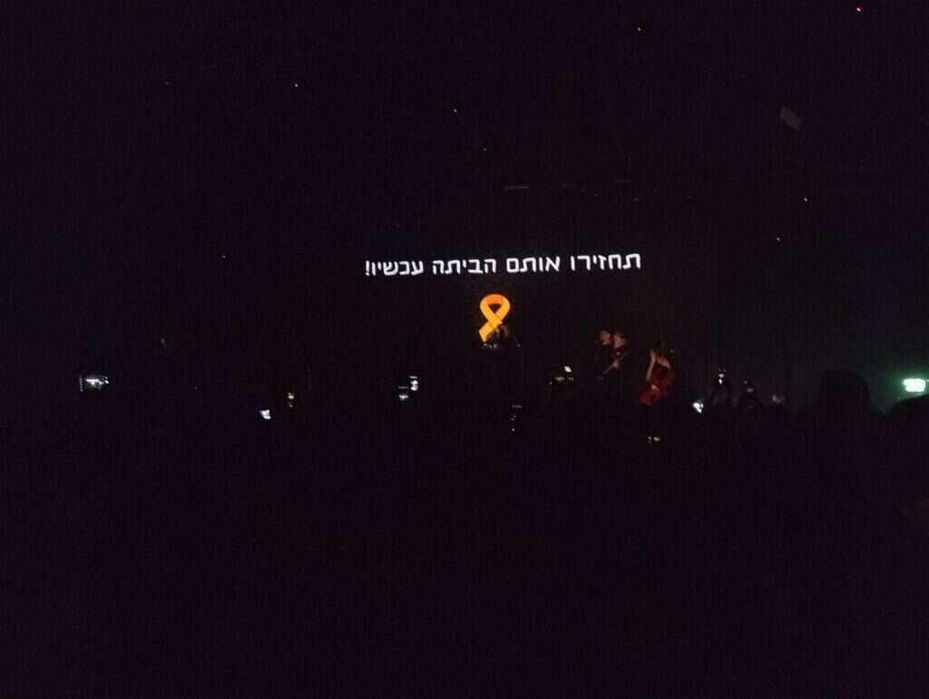 הכיתוב לשחרור החטופים בהופעה. | מקור ראשון