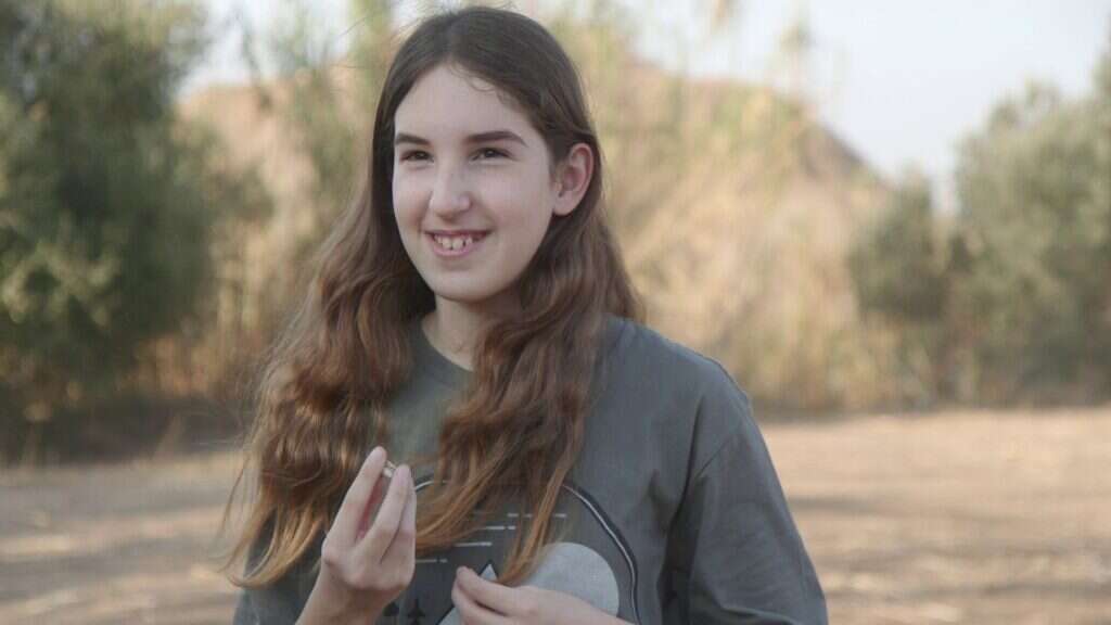 דפנה בת ה-12 עם הממצא המיוחד שגילתה. | אמיל אלג'ם, רשות העתיקות