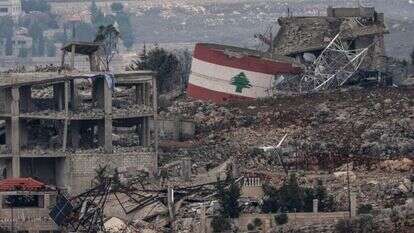 דגל לבנון על רקע ההריסות בכפר בדרום המדינה. | EPA