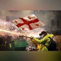 תומכי האופוזיציה בגיאורגיה יורים זיקוקים על בניין הפרלמנט. | EPA