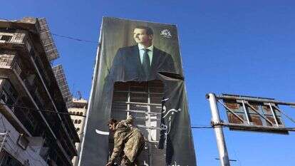 מורד סורי קורע כרזה של נשיא סוריה, בשאר אל-אסד. | EPA