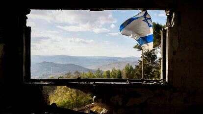 דגל ישראל על בית שניזוק מתקיפות חיזבאללה במנרה שבצפון. | AFP
