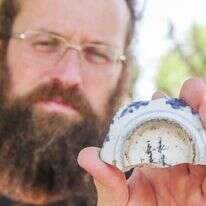 מיכאל טשרנין מרשות העתיקות עם הכתובת שנמצאה. | אמיל אלג'ם, רשות העתיקות