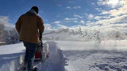 אדם מפלס שלג בצפון מערב מדינת ניו יורק. | AP Photo/Cara Anna
