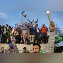 פליטים סורים בטורקיה חוגגים את מפלתו של אסד תוך שהם מנופפים בתמונתו של ארדואן. | אי.אף.פי פליטים סורים בטורקיה חוגגים את מפלתו של אסד תוך שהם מנופפים בתמונתו של ארדואן. | אי.אף.פי