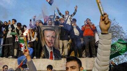 פליטים סורים בטורקיה חוגגים את מפלתו של אסד תוך שהם מנופפים בתמונתו של ארדואן. | אי.אף.פי פליטים סורים בטורקיה חוגגים את מפלתו של אסד תוך שהם מנופפים בתמונתו של ארדואן. | אי.אף.פי