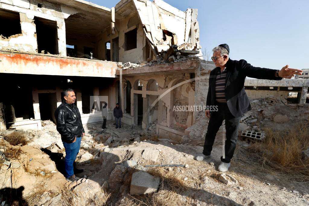 Bakhour Chamantoub, 74, right, the head of the Jewish community in Syria and one of the people who refused to leave Syria despite opportunities abroad and the nearly 14-year-old war, speaks with a Syrian man during his visit to the destroyed Jobar Synagogue, also known as Eliyahu Hanavi, in Jobar neighborhood, in Damascus, Syria, Thursday, Dec. 26, 2024. (AP Photo/Omar Sanadiki) Bakhour Chamantoub, 74, right, the head of the Jewish community in Syria and one of the people who refused to leave Syria despite opportunities abroad and the nearly 14-year-old war, speaks with a Syrian man during his visit to the destroyed Jobar Synagogue, also known as Eliyahu Hanavi, in Jobar neighborhood, in Damascus, Syria, Thursday, Dec. 26, 2024. (AP Photo/Omar Sanadiki)