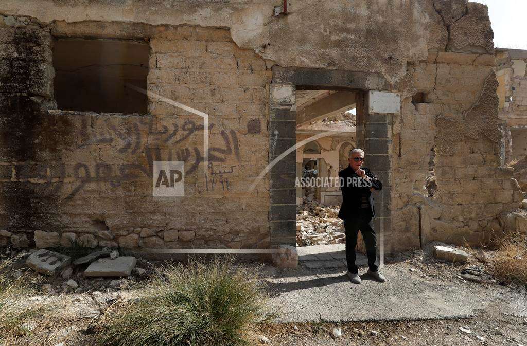 Bakhour Chamantoub, 74, right, the head of the Jewish community in Syria and one of the people who refused to leave Syria despite opportunities abroad and the nearly 14-year-old war, stands in front the destroyed Jobar Synagogue, also known as Eliyahu Hanavi, in Jobar neighborhood, in Damascus, Syria, Thursday, Dec. 26, 2024. The Arbic words on the wall read:"Syria Assad, the republican gauard." (AP Photo/Omar Sanadiki) Bakhour Chamantoub, 74, right, the head of the Jewish community in Syria and one of the people who refused to leave Syria despite opportunities abroad and the nearly 14-year-old war, stands in front the destroyed Jobar Synagogue, also known as Eliyahu Hanavi, in Jobar neighborhood, in Damascus, Syria, Thursday, Dec. 26, 2024. The Arbic words on the wall read:"Syria Assad, the republican gauard." (AP Photo/Omar Sanadiki)
