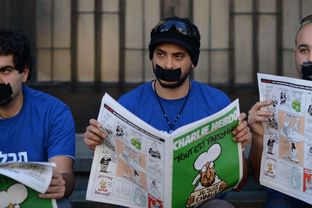 פעיל ישראלי אוחז בעיתון "שארלי הבדו". | בן קלמר, פלאש90 Ben