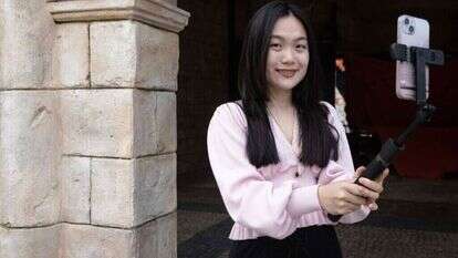 משפיענית מצלמת סרטון ל-Xiaohongshu | AFP