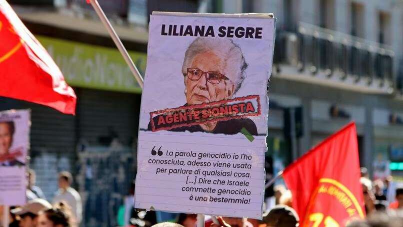 כרזה שהונפה בהפגנה באיטליה ועליה דמותה של שורדת השואה ליליאנה סגרה עם הכיתוב "סוכנת ציונית". | מסך מיוטיוב כרזה שהונפה בהפגנה באיטליה ועליה דמותה של שורדת השואה ליליאנה סגרה עם הכיתוב "סוכנת ציונית". | מסך מיוטיוב