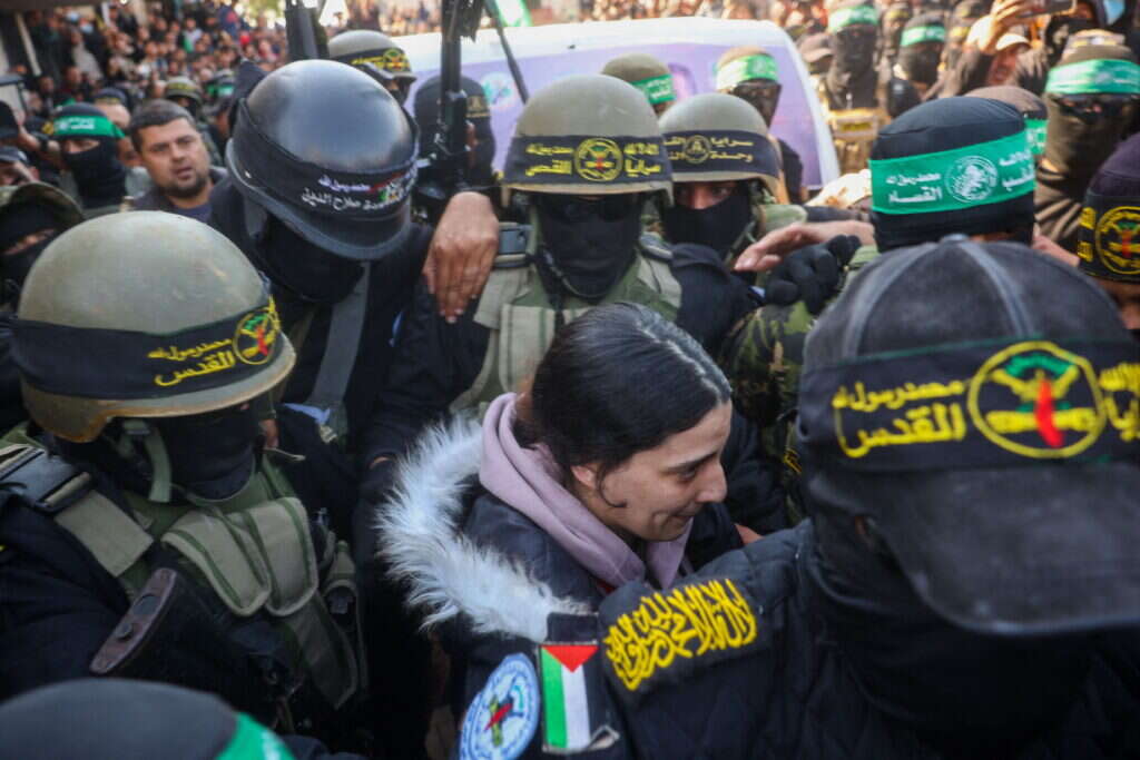 ארבל יהוד מובלת על ידי המחבלים בעת שחרורה מהשבי, לפני עלייתה לרכב הצלב האדום. | AFP