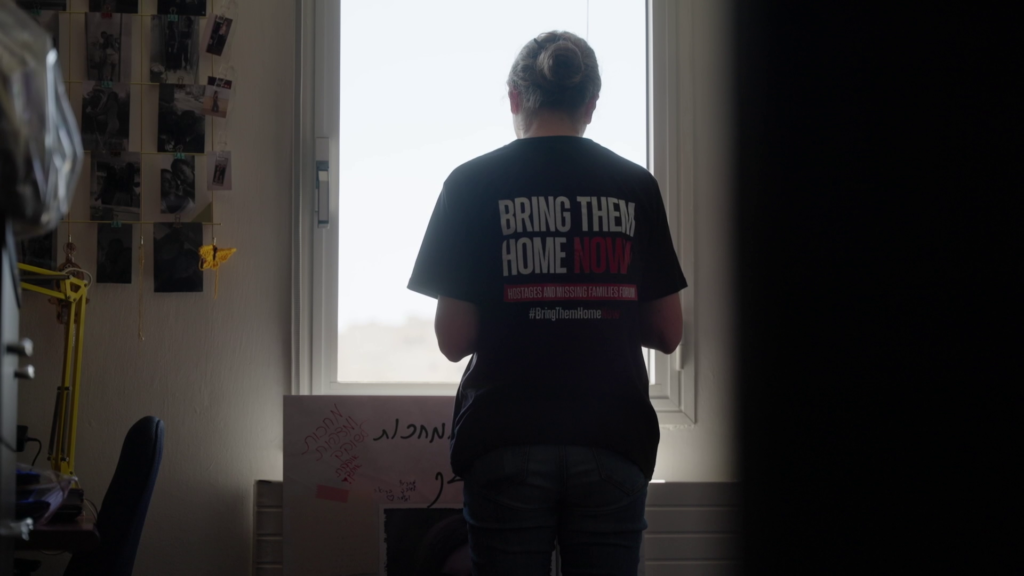 אירה מתפללת לשובה של קרינה מידי יום בחדרה של קרינה. מתוך הסרט "חטופות"