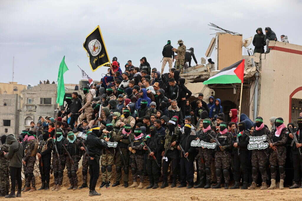 מחבלי חמאס בעת העברת גופות החטופים החללים. | AFP