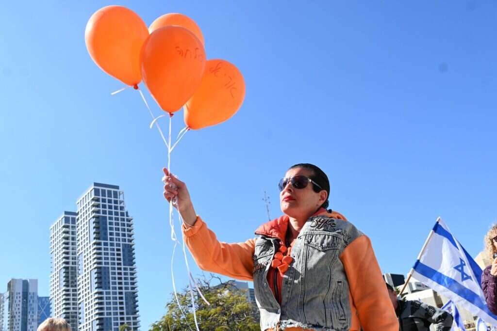 מפריחים בלונים כתומים לזכר בני משפחת ביבס בכיכר החטופים. | פאולינה פטימר