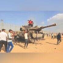 פלסטינים שחדרו לישראל מצטלמים עם טנק של צה"ל, 7 באוקטובר 2023. | AFP פלסטינים שחדרו לישראל מצטלמים עם טנק של צה"ל, 7 באוקטובר 2023. | AFP