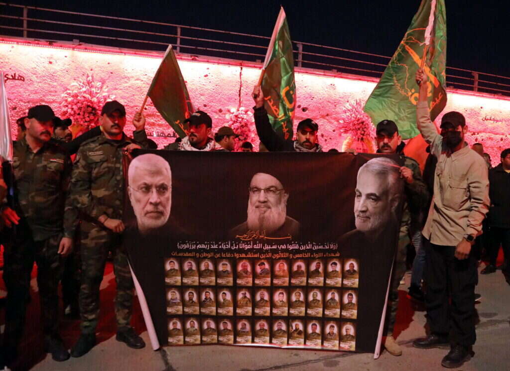 פעילי המיליציות הפרו-איראניות בעיראק מחזיקים בכרזה הנושאת את תמונותיהם של מפקד כוח קודס של משמרות המהפכה האיראני שחוסל, קאסם סולימאני, מנהיג חיזבאללה שחוסל, חסן נסראללה, וסגנו של מנהיג המיליציות שחוסל, אבו-מהדי אל-מוהנדס | EPA