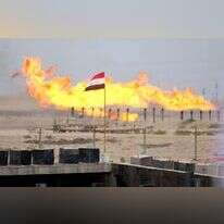 דגל עיראק מתנוסס מול שריפת עודפי גז צינור, ארכיון | AFP