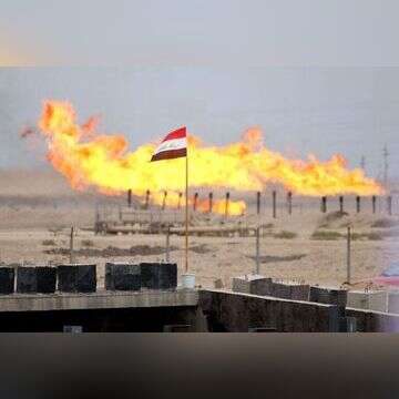 דגל עיראק מתנוסס מול שריפת עודפי גז צינור, ארכיון | AFP