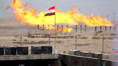 דגל עיראק מתנוסס מול שריפת עודפי גז צינור, ארכיון | AFP