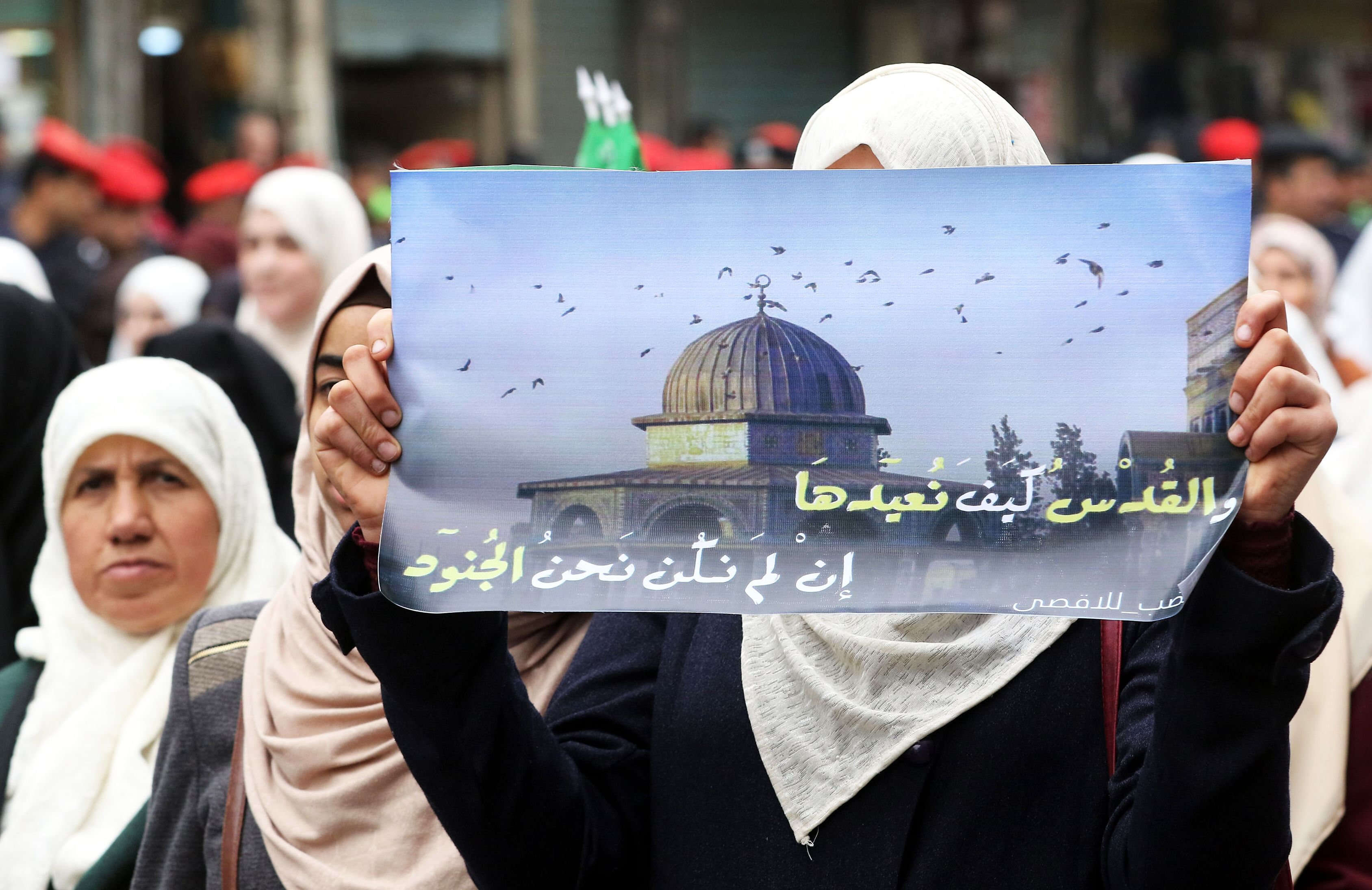 אישה מוסלמית מניפה כרזה של הר הבית. | AFP