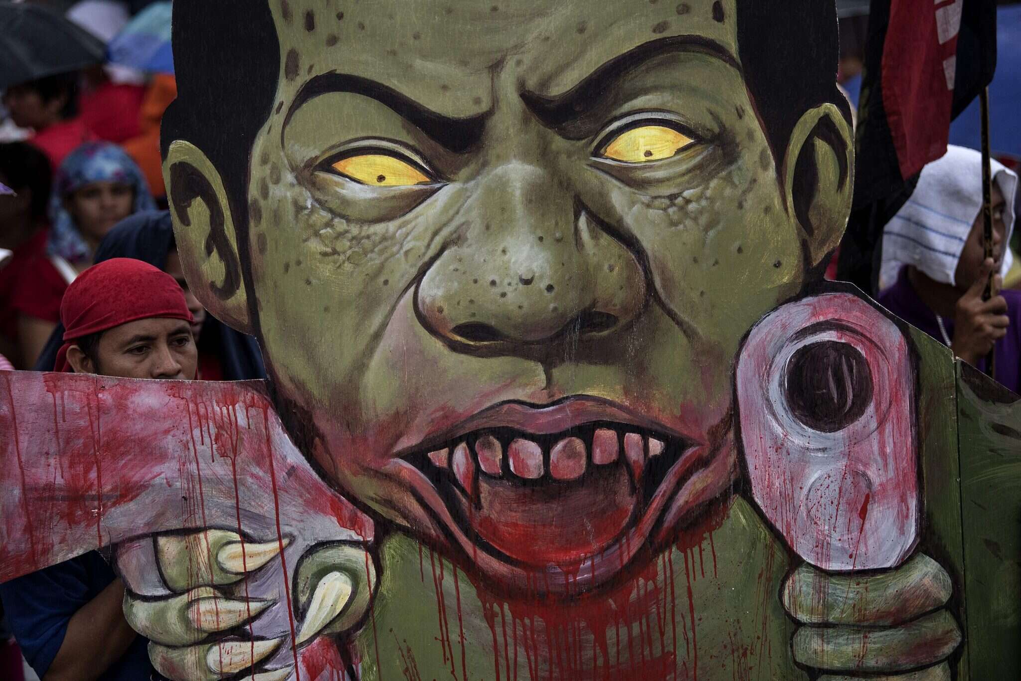 שלט שבו מוצג דוטרטה כרודן צמא דם. | AFP