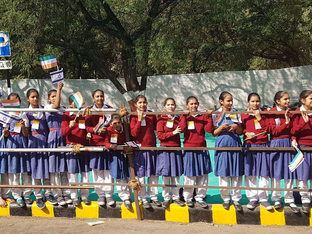 תלמידות בית ספר מנופפות בדגלי ישראל והודו. אלפי בני אדם גודשים את הרחובות. | שירית אביטן כהן