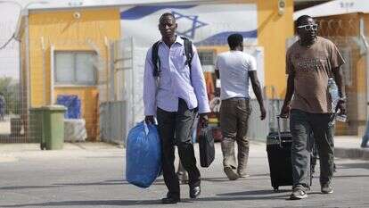 מהגרים מחוץ למתקן חולות. | AFP