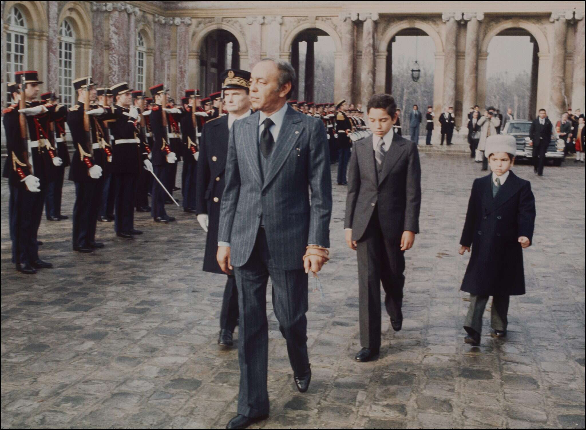 מוביל ההפיכה נמצא מת, כשראשו מונח על "הפיכה: מדריך מעשי". חסן השני מלך מרוקו עם בניו בצרפת, 1976. | AFP