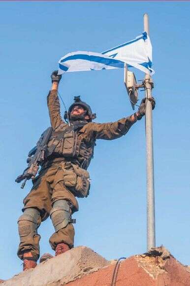 שי שמריז ז"ל מניף את הדגל על גג בית העירייה בג'בלייה | באדיבות המשפחה שי שמריז ז"ל מניף את הדגל על גג בית העירייה בג'בלייה | באדיבות המשפחה