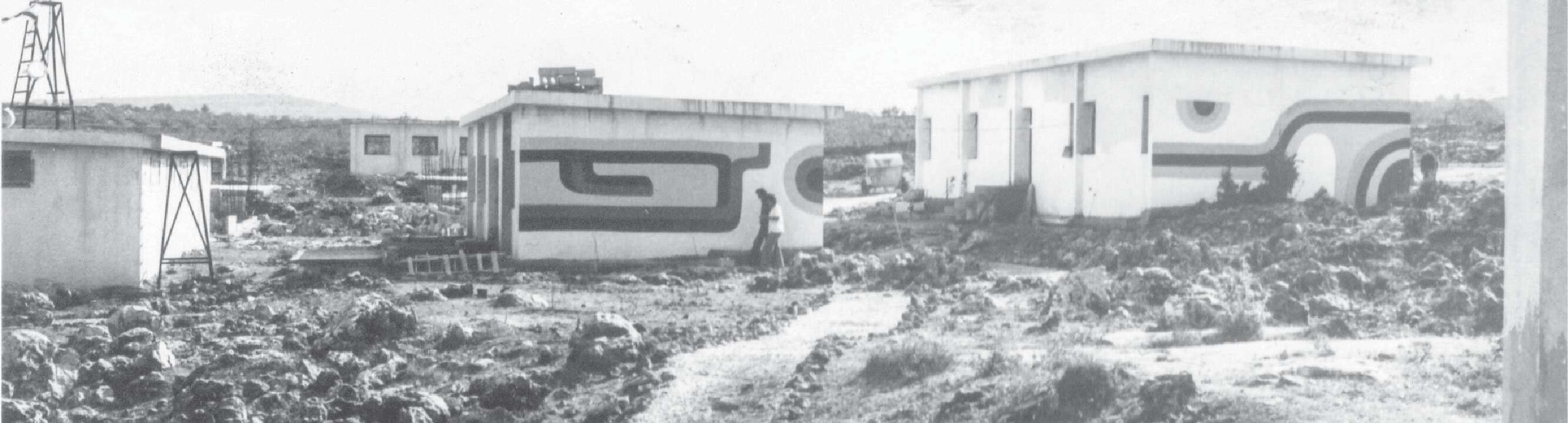 "העסיקה אותנו המחשבה איך בונים יישוב שהוא לא מושב, קיבוץ או יישוב עירוני". ארבעת המבנים הירדניים ברחוב הפלמ"ח. משמאל: היום הראשון בעפרה, 1975 | פנחס ולרשטיין "העסיקה אותנו המחשבה איך בונים יישוב שהוא לא מושב, קיבוץ או יישוב עירוני". ארבעת המבנים הירדניים ברחוב הפלמ"ח. משמאל: היום הראשון בעפרה, 1975 | פנחס ולרשטיין